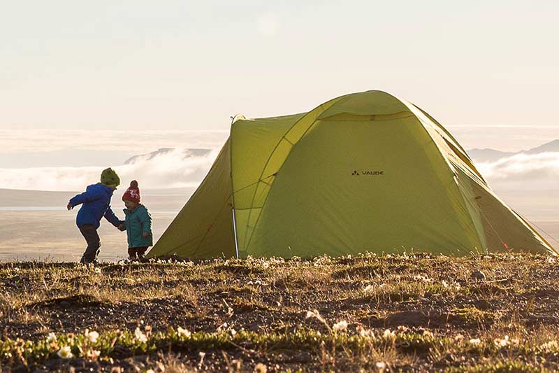 kinds playing in front of a tent