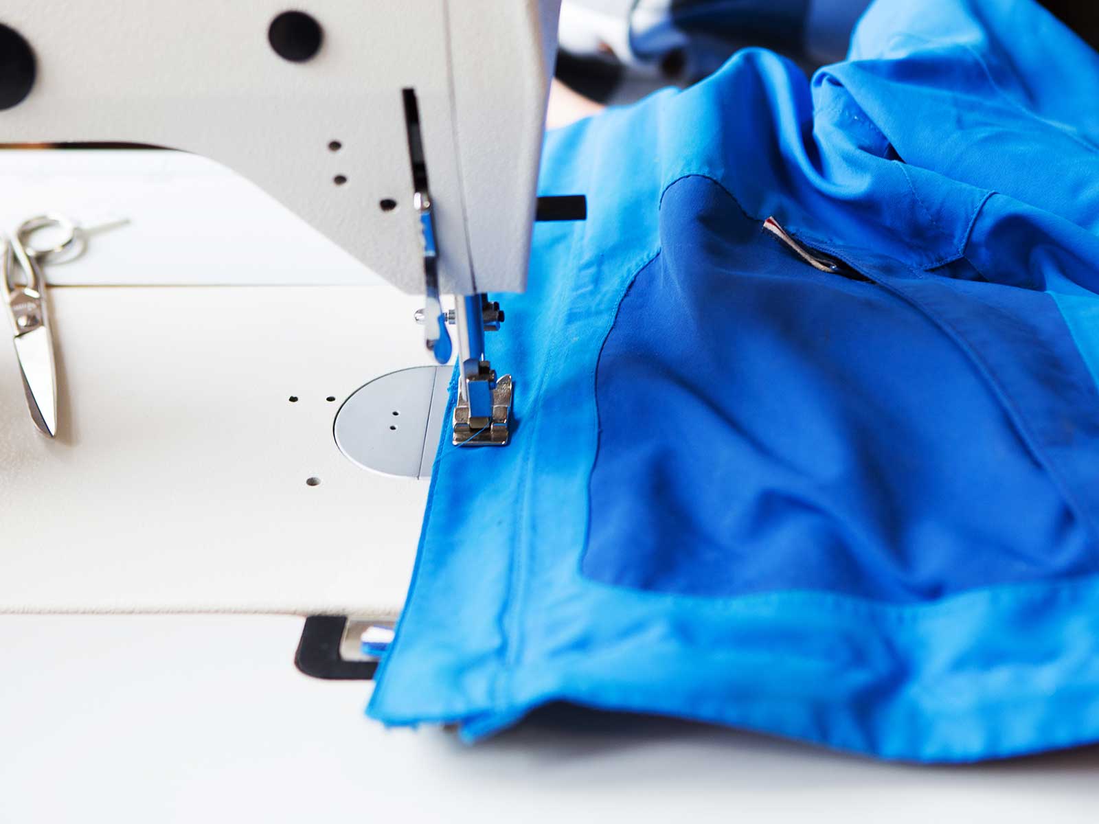 Jacke liegt unter Nähmaschine