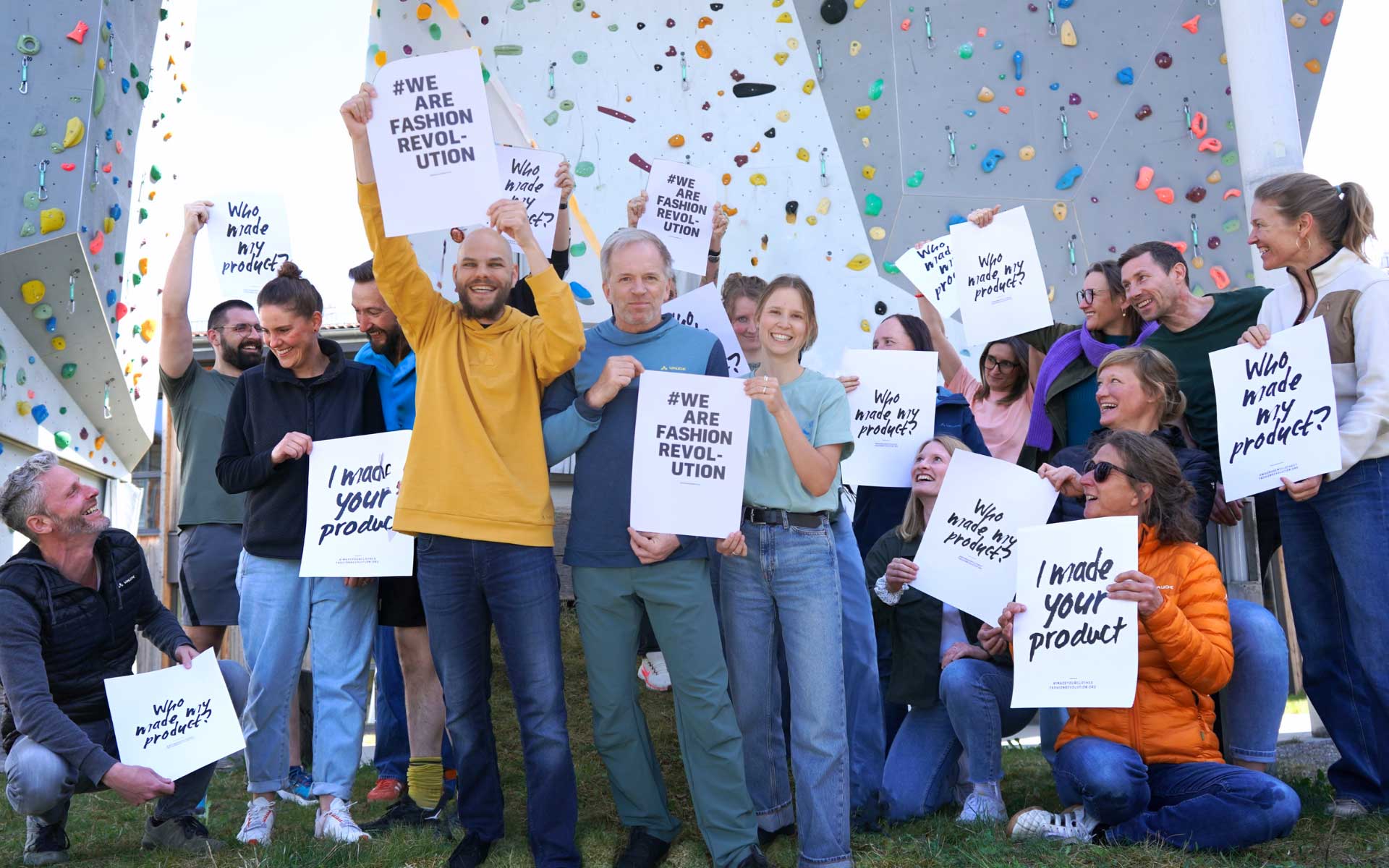 vaude team posing in front of a climbing wall