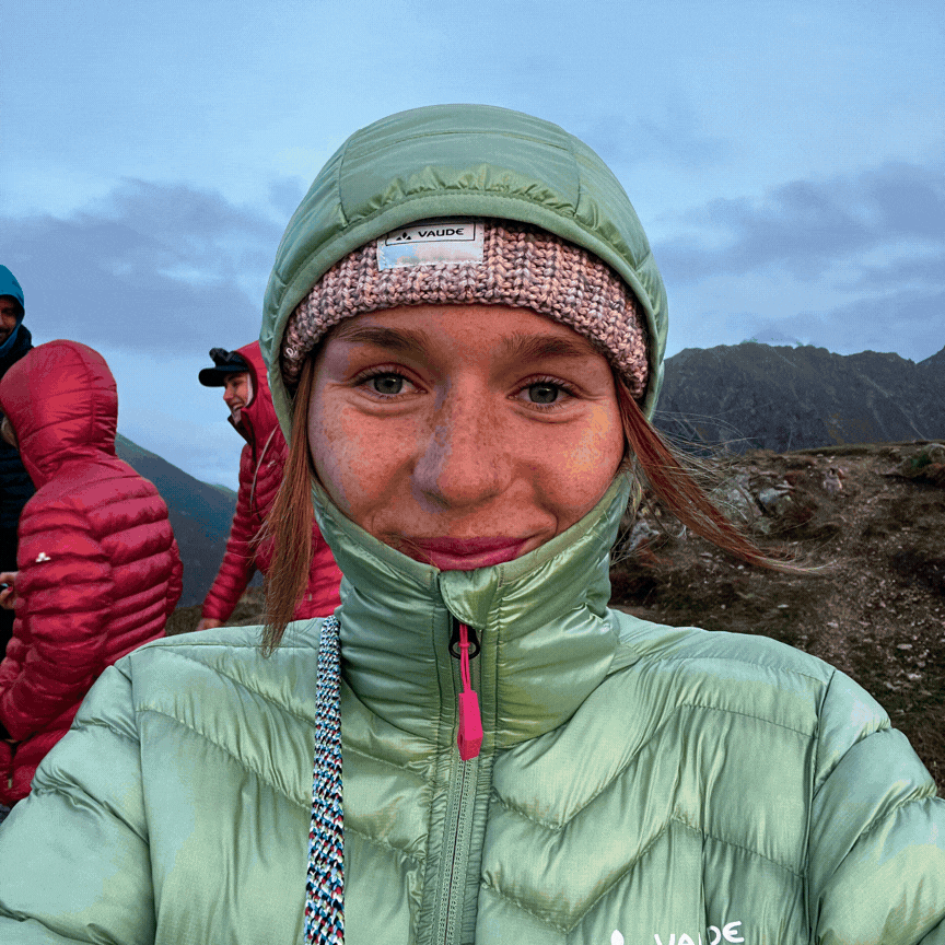 Frau im Schnee mit Helm und zwei M&auml;nner in Jacken