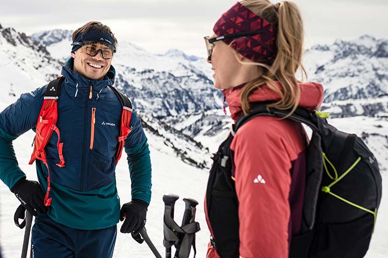 VAUDE Rucksäcke entdecken mann und frau stehen auf Schnee bedecktem Berg mit Rucksäcken drauf