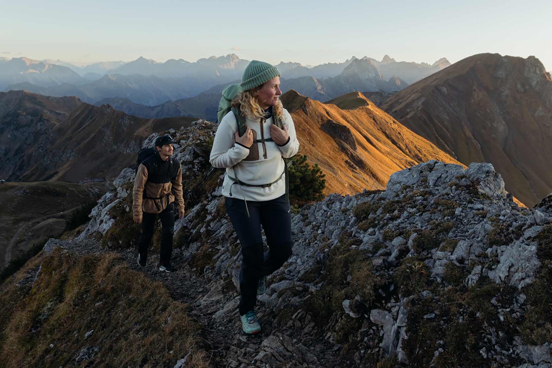 VAUDE Produkte entdecken Frau und Mann wandern auf Berggrat
