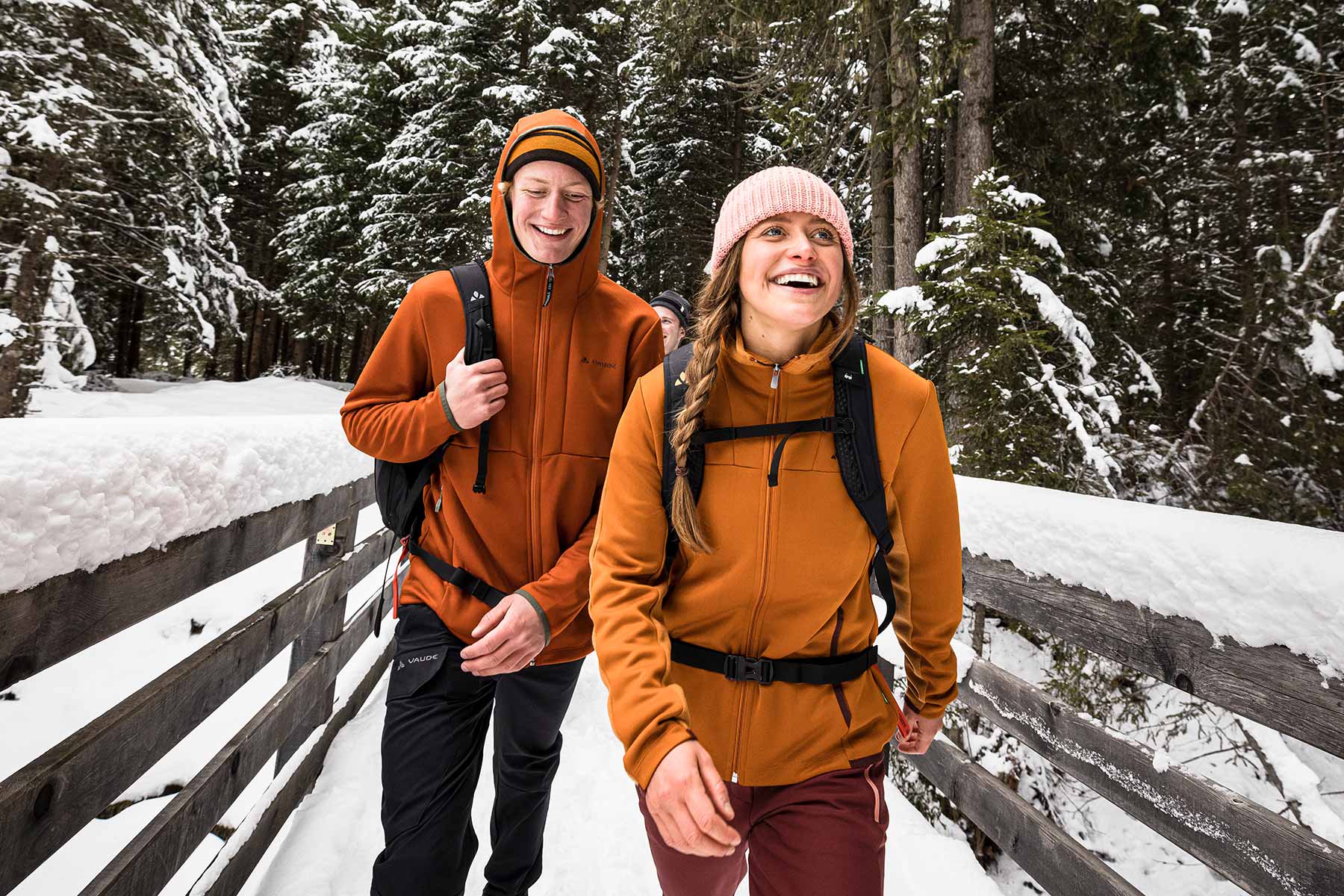 Winterwandern entdecken! Frau und Mann wandern durch Winterwald