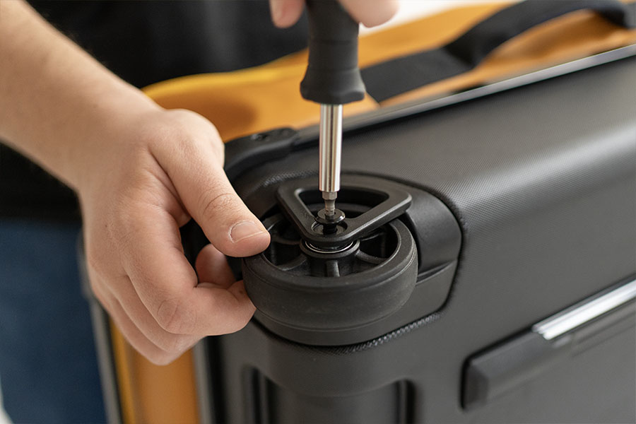 Mit einem Schraubendreher wird die Schraube der Rolle rausgedreht