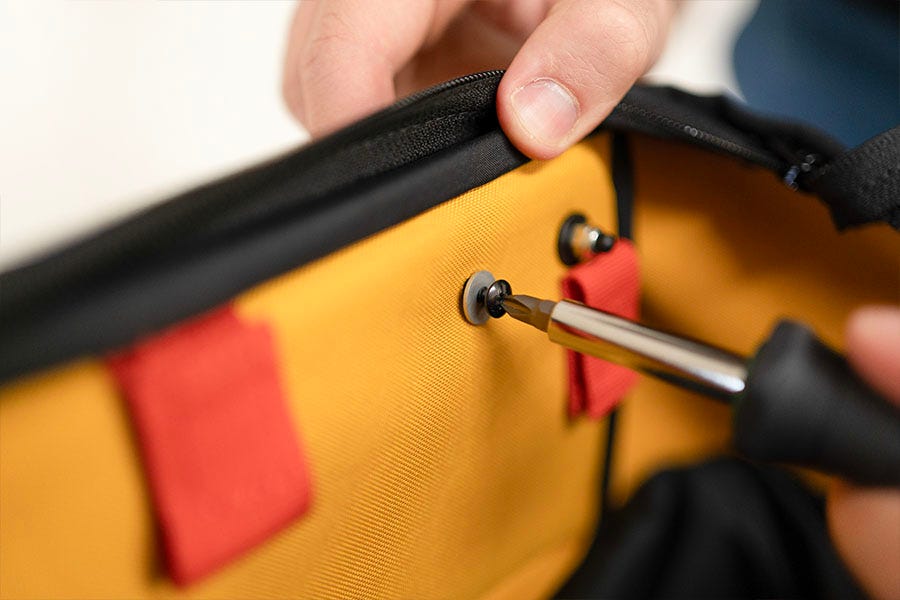 Die Schraube wird mit einem Schraubendreher gelöst