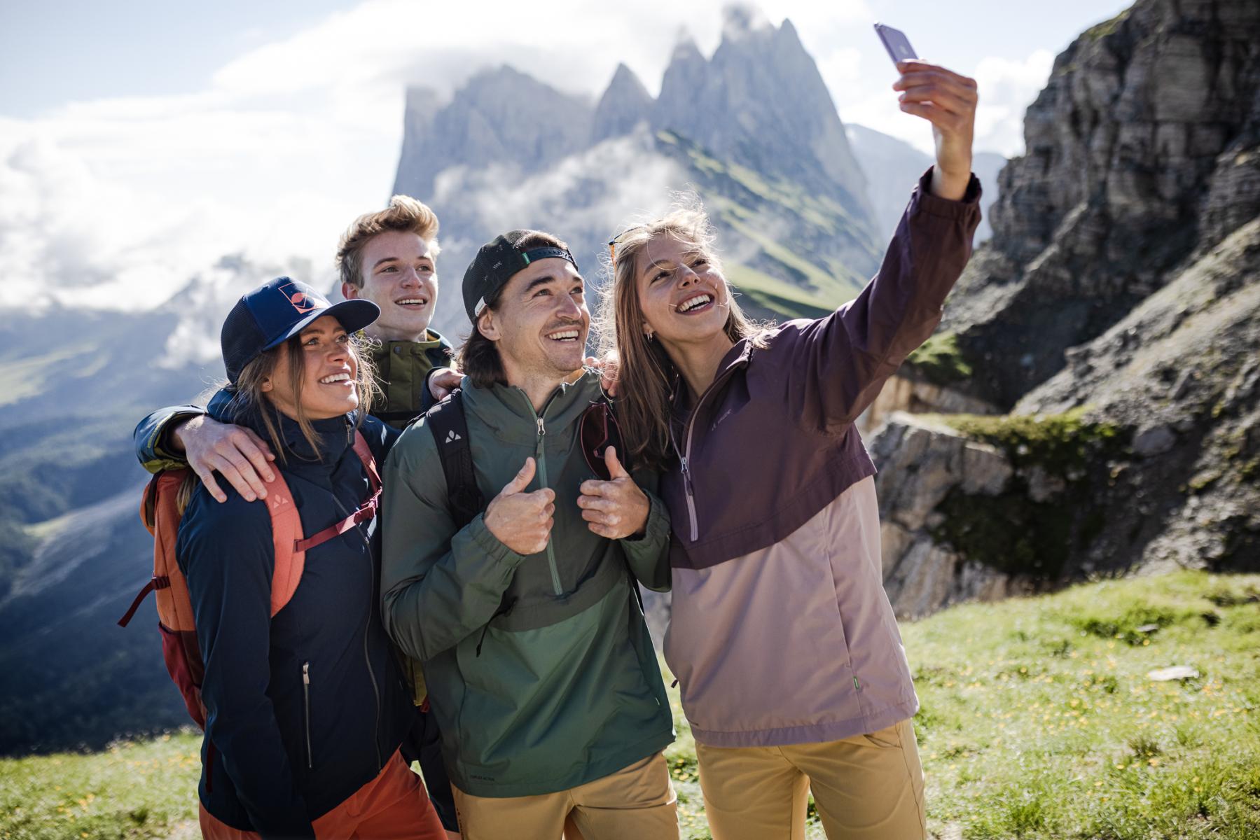 Vier junge Menschen fotografieren sich selbst mit einem Handy