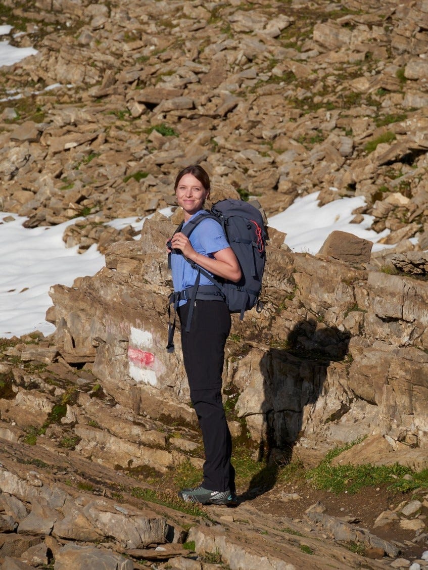 Frau mit Rucksack beim Wandern in den Bergen