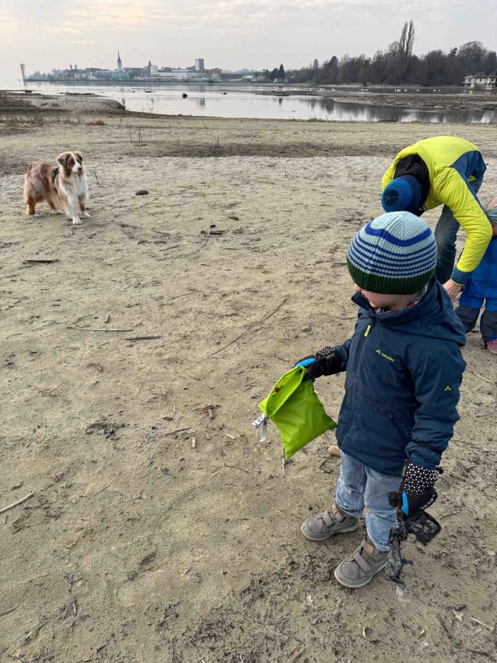 Ein Kind mit VAUDE Plogging Bag am Strand.