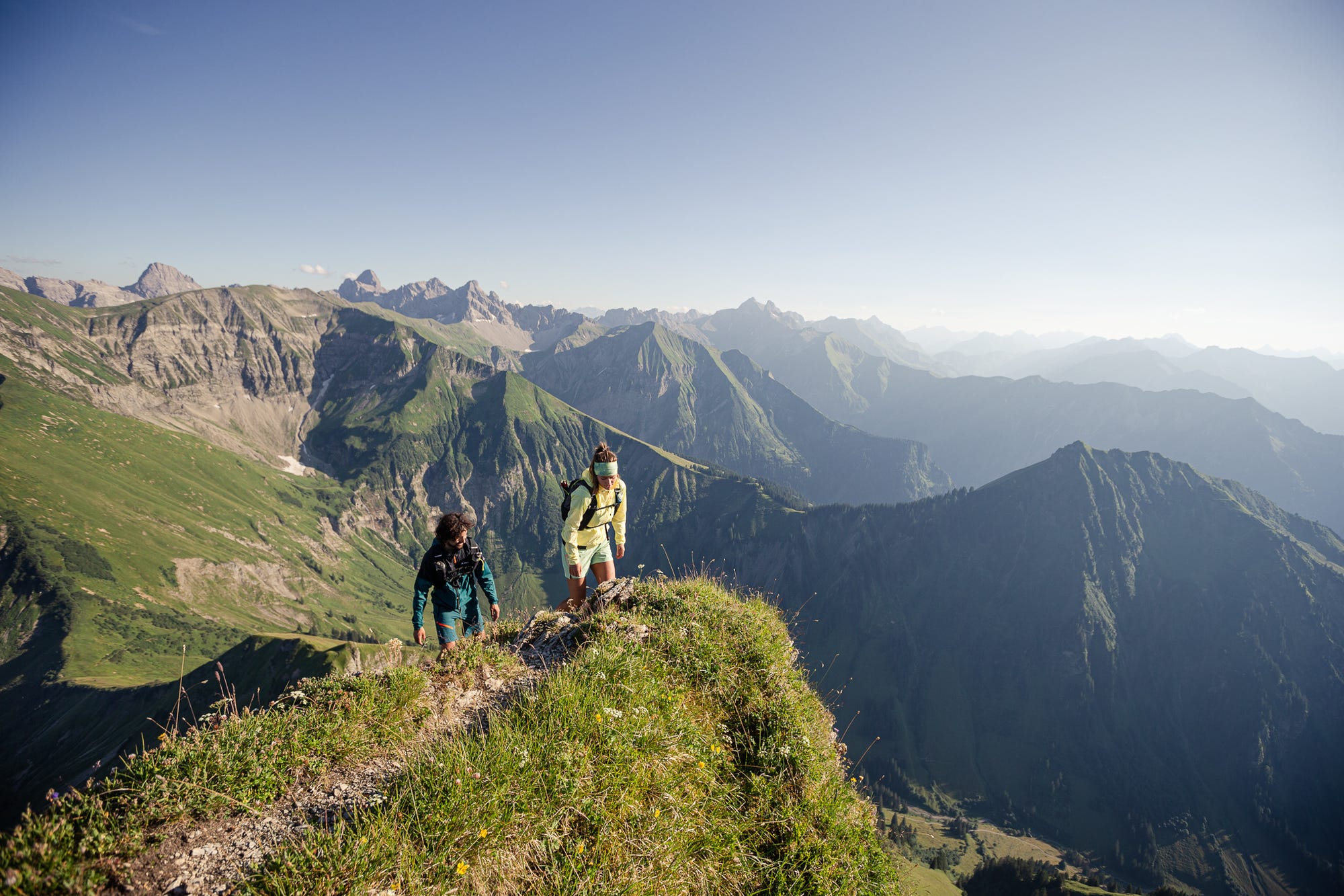 Wandernde auf Gipfelpfad mit Aussicht über die Berge