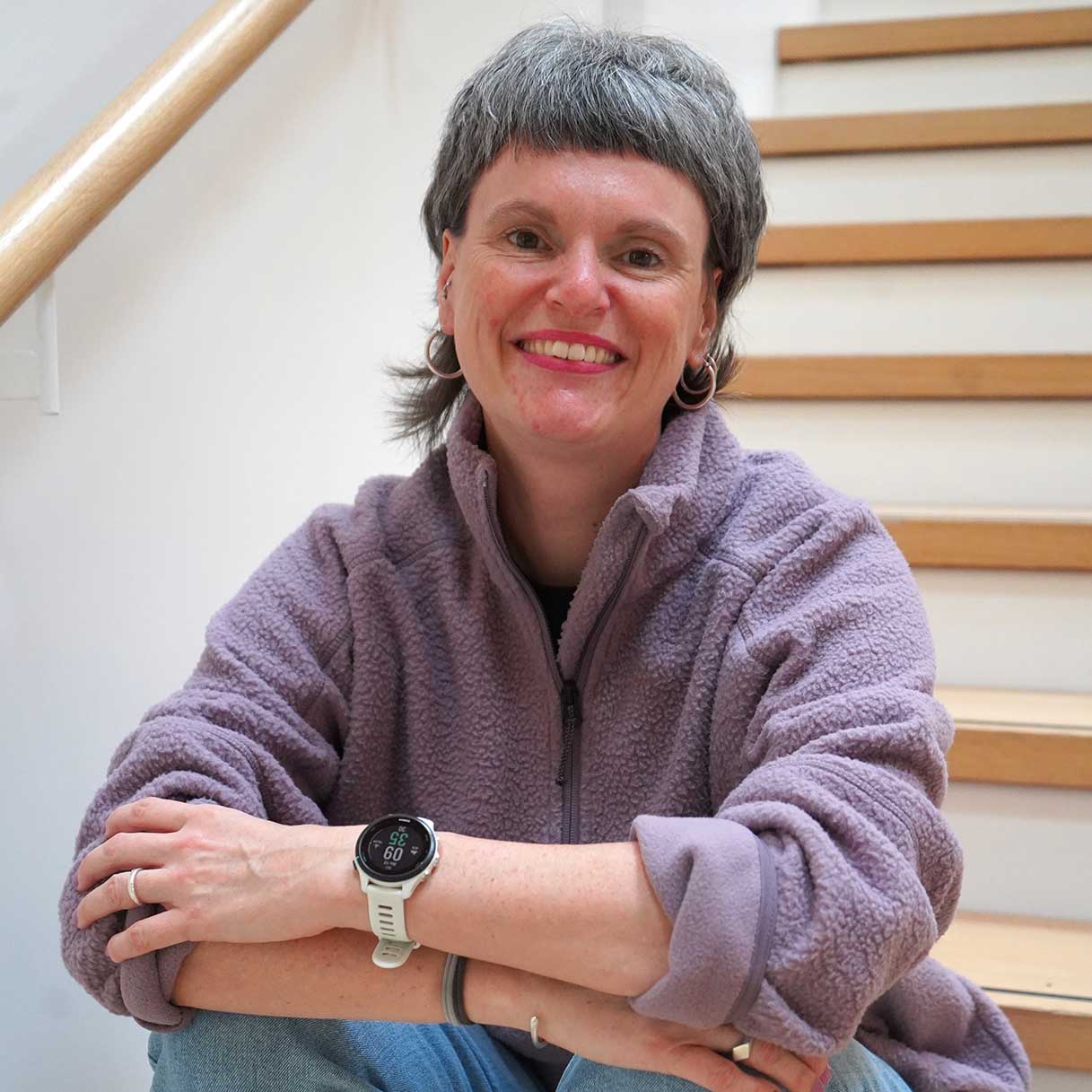 Mitarbeiterin VAUDE, sitzend auf einer Treppe