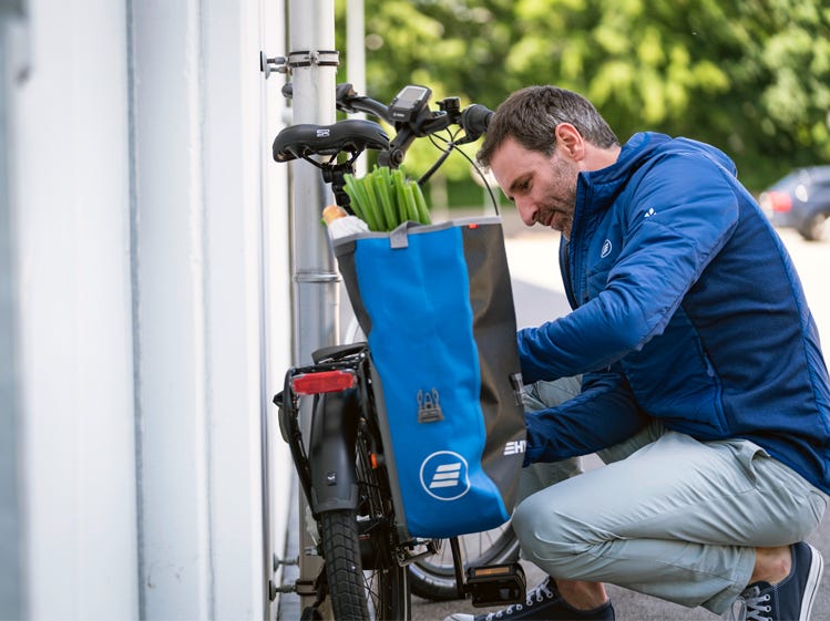 Ein Mann verstaut seine Einkäufe in der Fahrradtasche