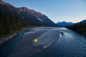 Ein Zelt auf einer Kiesinsel an einem Fluss
