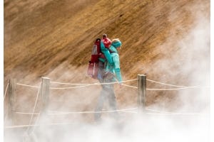 Eine Frau mit einem Kind in einer Kraxe auf dem Rücken