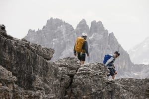 A man and a woman with rucksacks on a rocky ridge