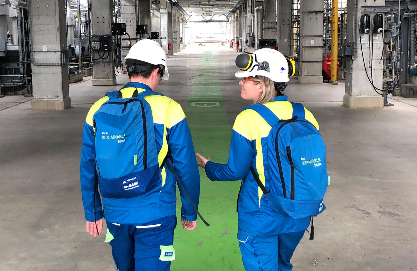 BASF Mitarbeiter von hinten durch eine Halle laufend